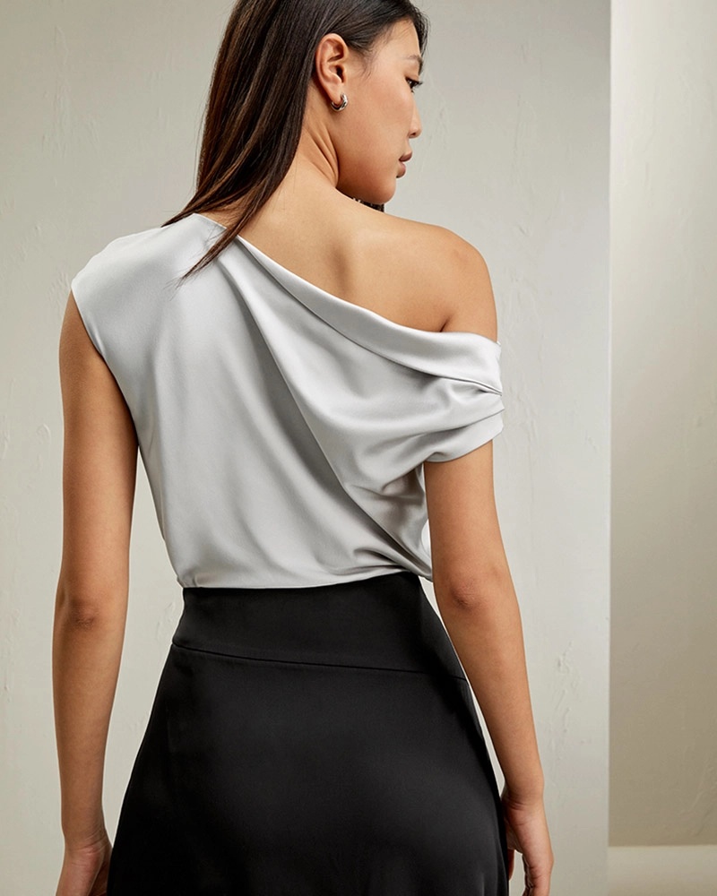 Fashion photo of a silk off-the-shoulder blouse paired with tailored trousers for an elegant street style look.